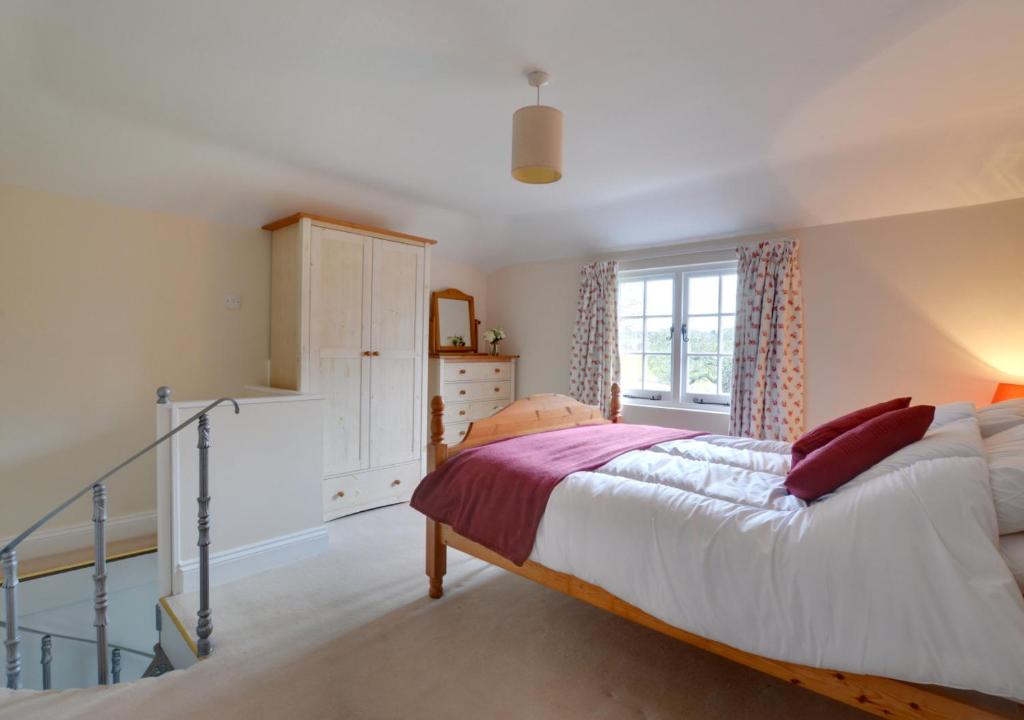 a bedroom with a large bed and a window at Well Cottage in Barham