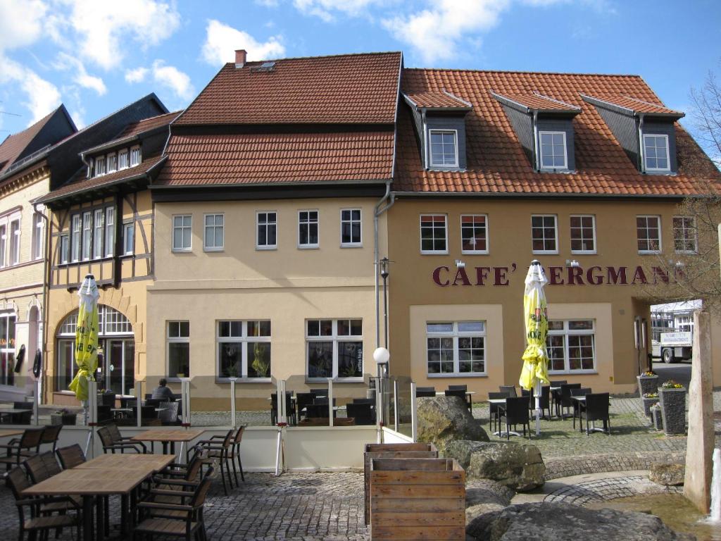 ein Gebäude mit Tischen und Stühlen davor in der Unterkunft Ferienwohnung Anger 18 in Bad Frankenhausen