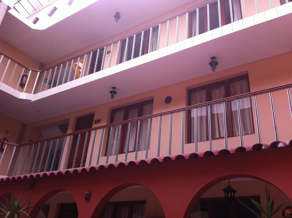 un edificio de apartamentos con balcón y ventanas en Hotel del Sur, en Cusco