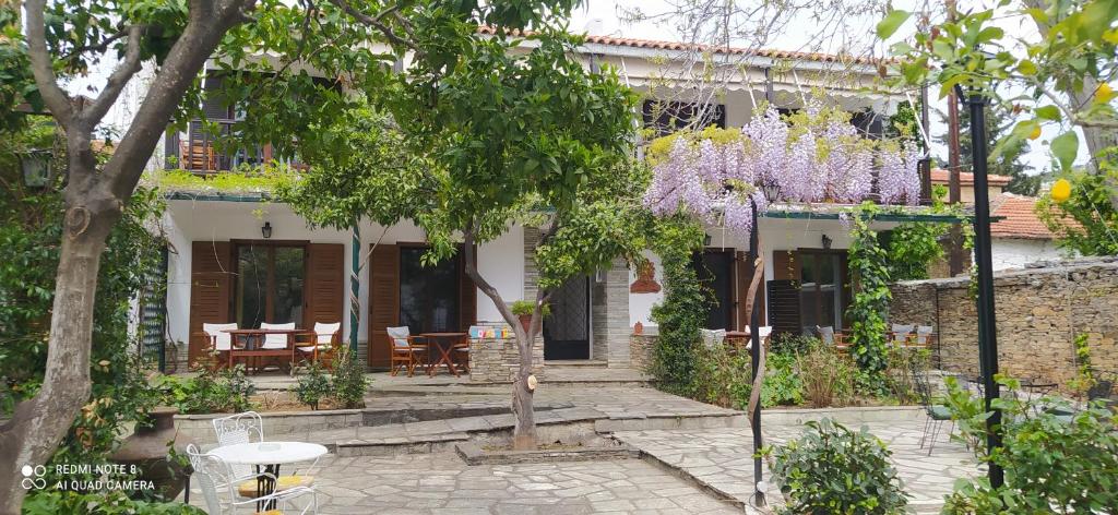 a house with a patio and trees in front of it at Mirto Apartments in Afissos