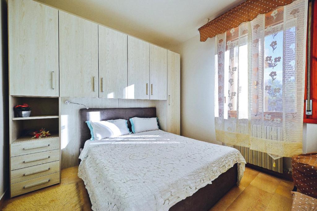 une chambre avec un grand lit et une fenêtre dans l'établissement Andry House, à Peschiera del Garda