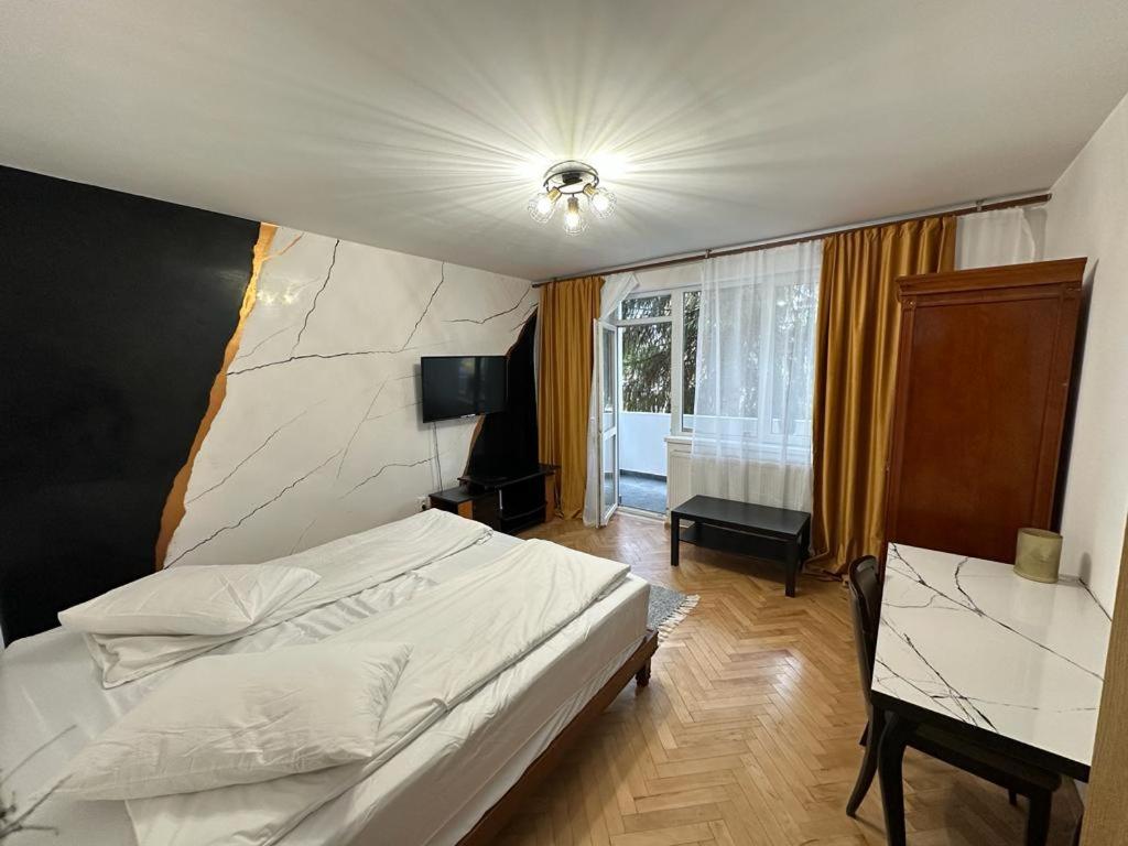 a bedroom with a bed and a desk and a window at Vidalis Suite in Cluj-Napoca