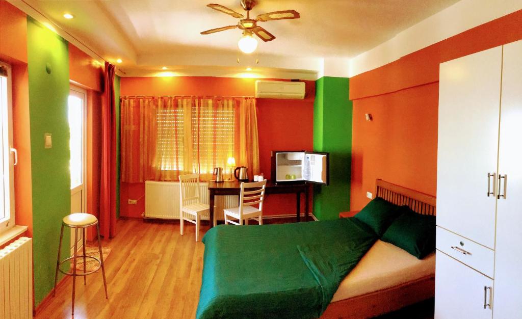 ein Schlafzimmer mit grünen und orangefarbenen Wänden und einem Tisch in der Unterkunft Antalyaloft in Antalya