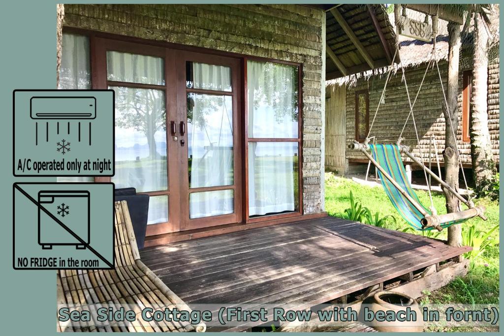 a porch with a swing and a hammock on a house at Coco Cottage - SHA Plus in Ko Ngai
