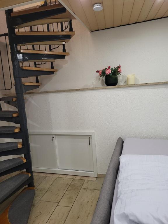 um quarto com uma cama e uma escada em espiral em Willkommen im Herzen Nürnbergs em Nurembergue