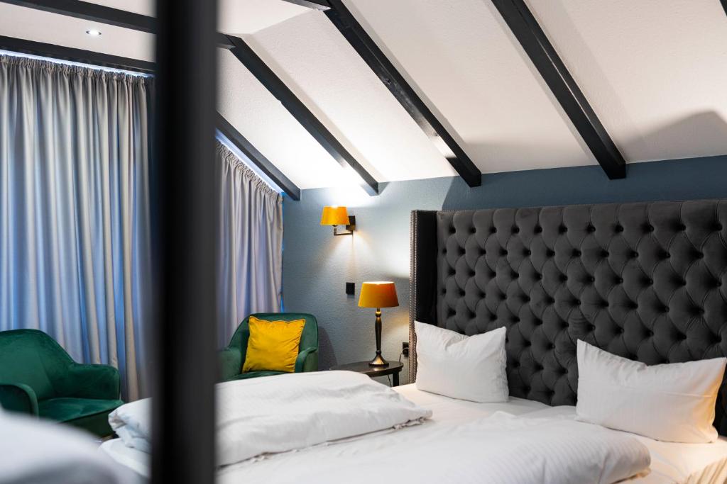 a hotel room with two beds and a headboard at Waldhotel Riesebusch in Bad Schwartau