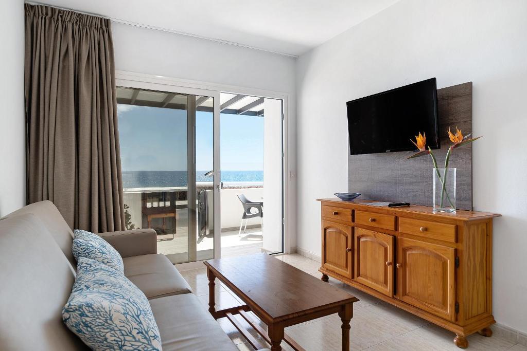 a living room with a couch and a tv at Callao Beach 3 in Arrieta