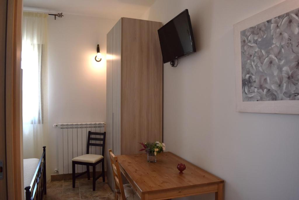 een kamer met een tafel en een televisie aan de muur bij Le Mimose in Pulsano
