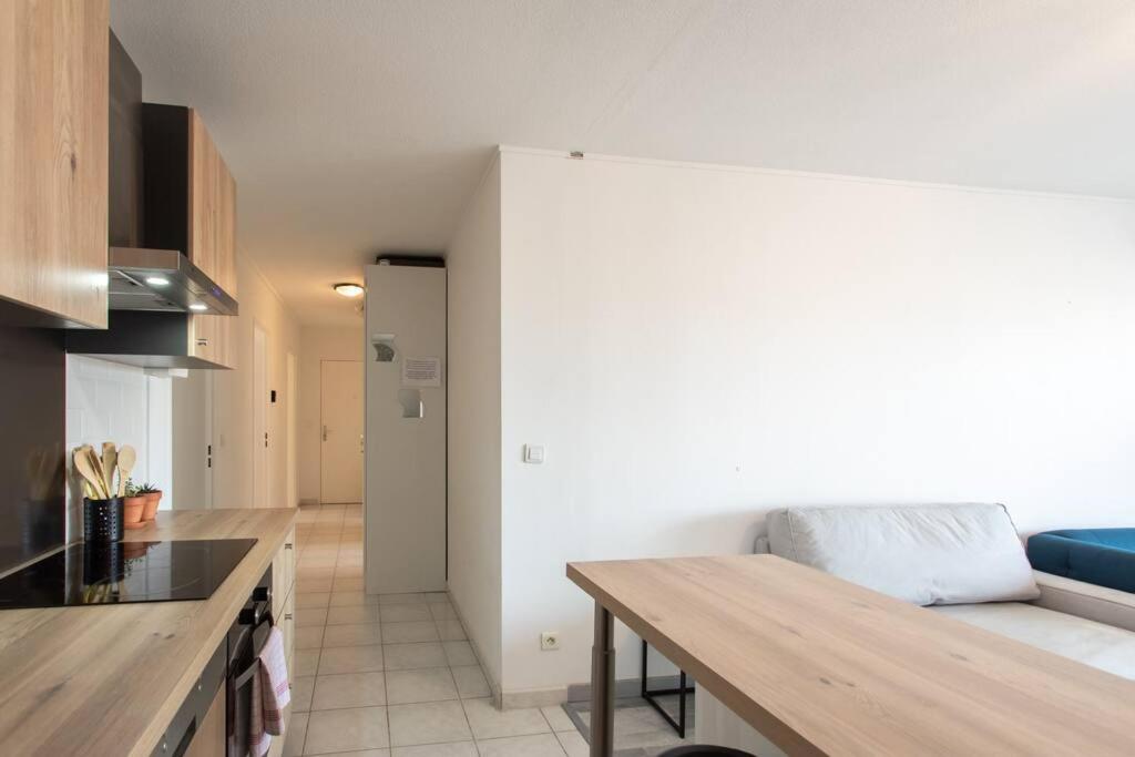a kitchen with a table and a couch in a room at L41 Suite Paladium parking 8pax 4rooms balcony WIFI&#47;AC in Nice