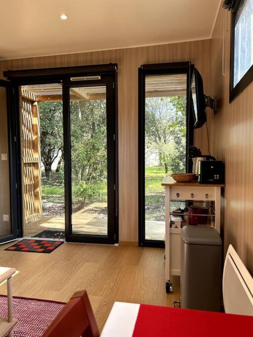 a room with two sliding glass doors and a table at Ma cabane sous les arbres in Soulac-sur-Mer