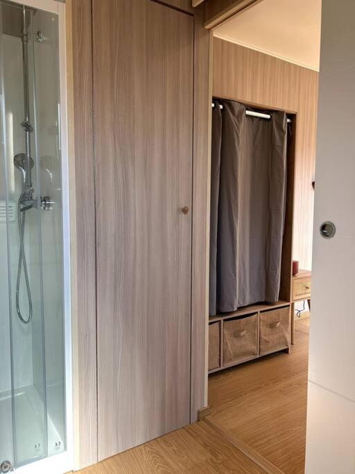 a bathroom with a shower and a glass door at Ma cabane sous les arbres in Soulac-sur-Mer