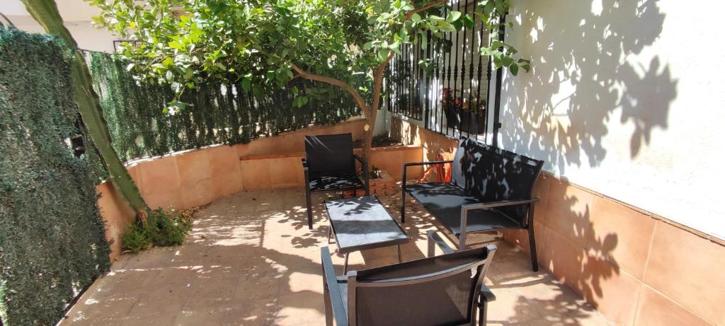 a group of chairs sitting on a patio next to a wall at Apartamento limonero ,VUT AL 13044 in Albox