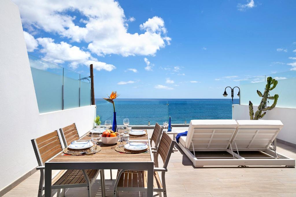 a dining room with a table and a view of the ocean at Callao Beach 6 in Arrieta
