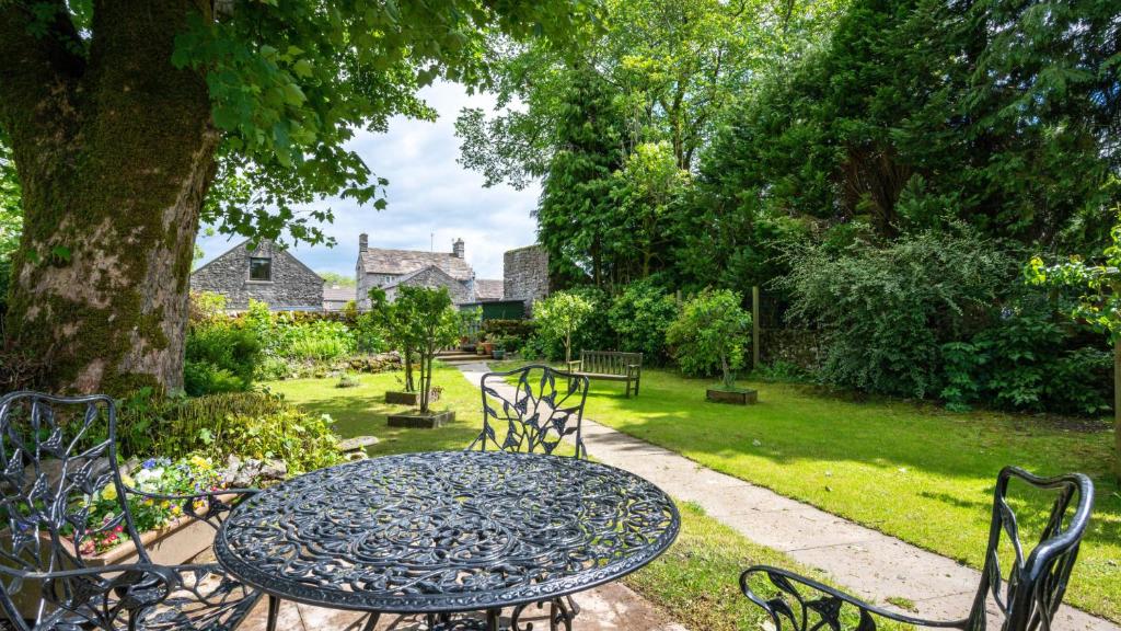 a table and chairs in a garden with a tree at Sheldon Barn in Monyash