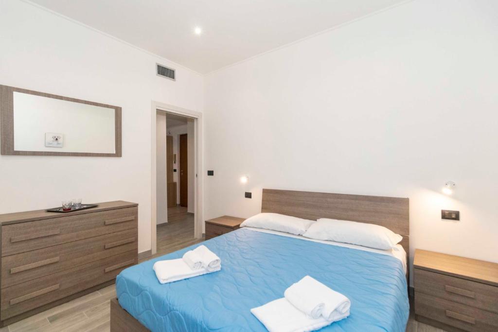 a bedroom with a blue bed with two towels on it at Lingotto Fair Comfy Apartment x4 - MM Italia 61 in Turin
