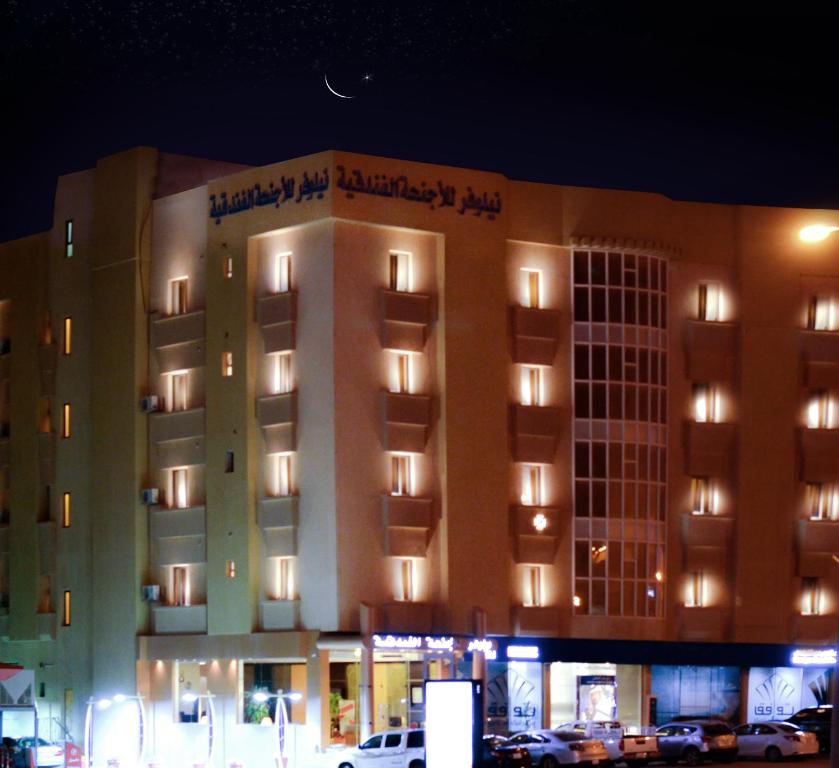 a large building with lights on it at night at Nelover Hotel Hafar in Hafr Al Baten