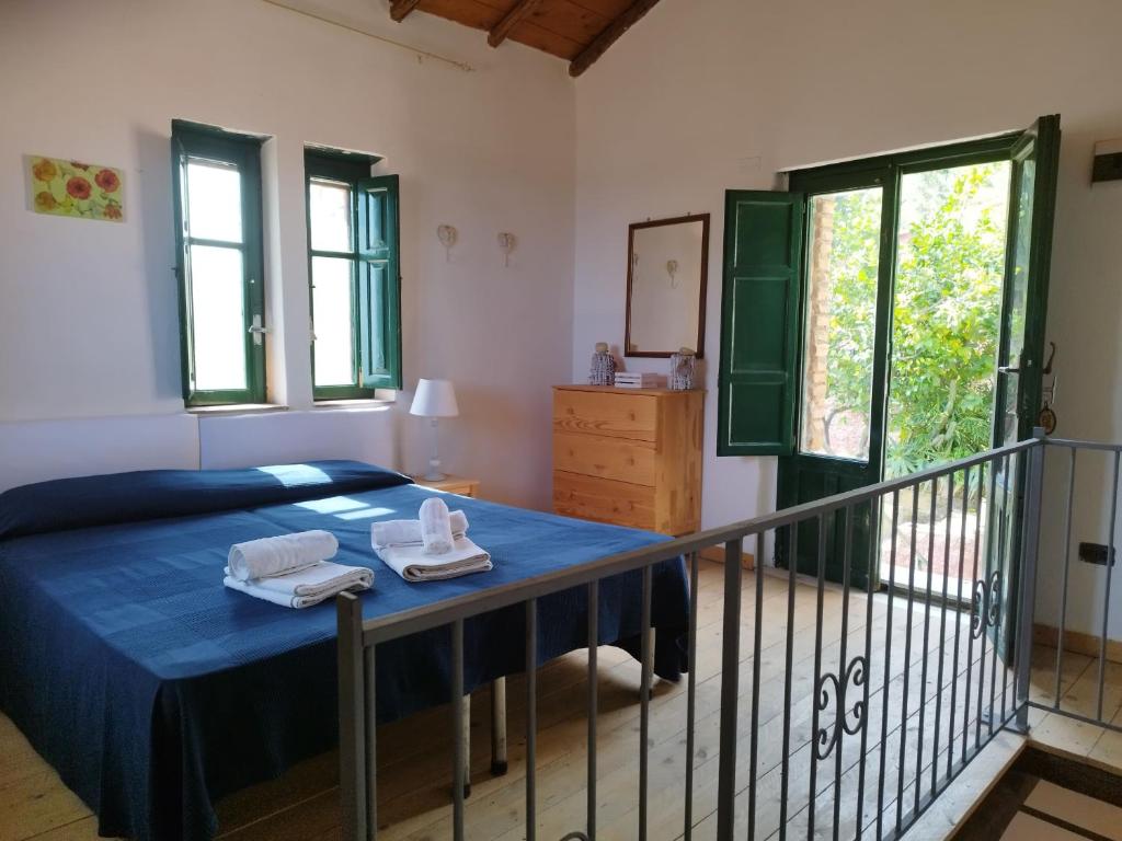 a bedroom with a bed and a balcony at Villette Monte Alto in Patti