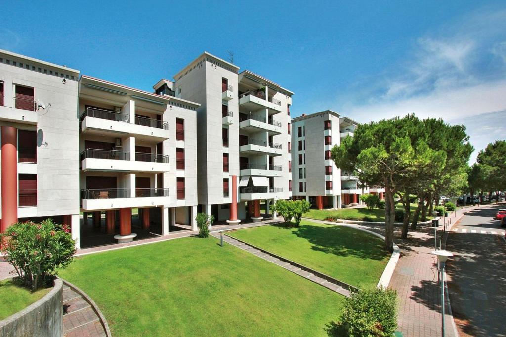 an apartment building with a lawn in front of it at Residenza Porta Del Mare in Lignano Sabbiadoro