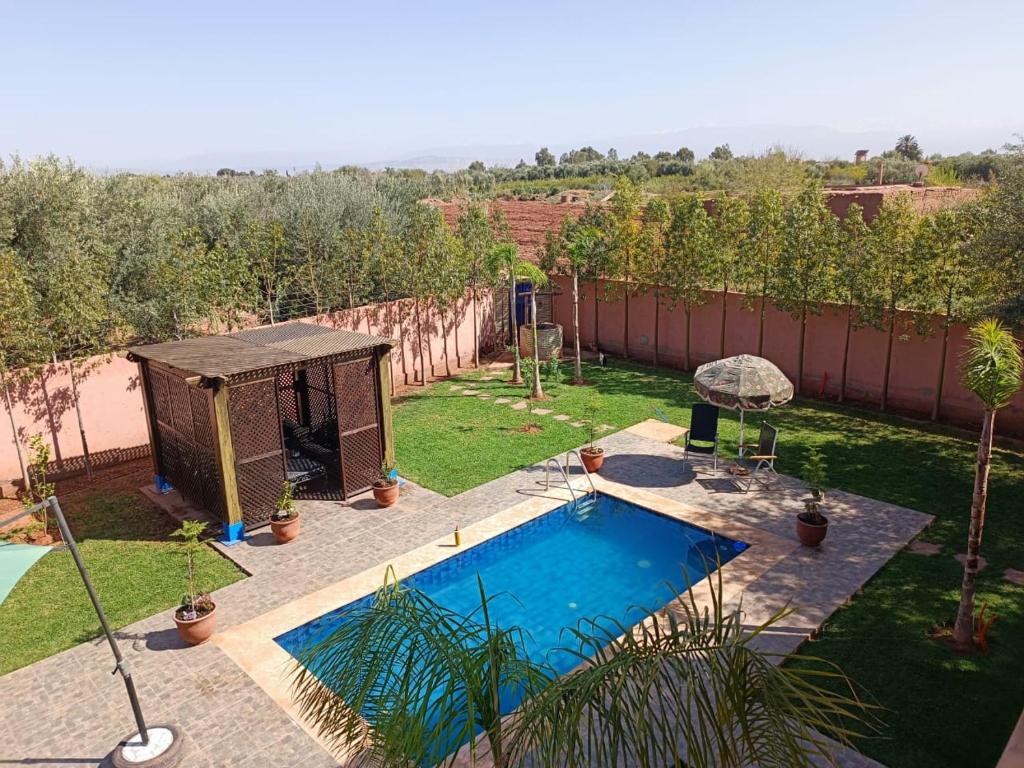 een achtertuin met een zwembad en een prieel bij Villa khaddouj Marrakech in Marrakesh