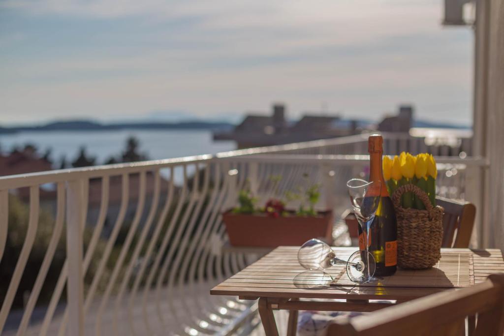 una mesa de madera en un balcón con vistas al agua en Apartment Hedonist, en Hvar