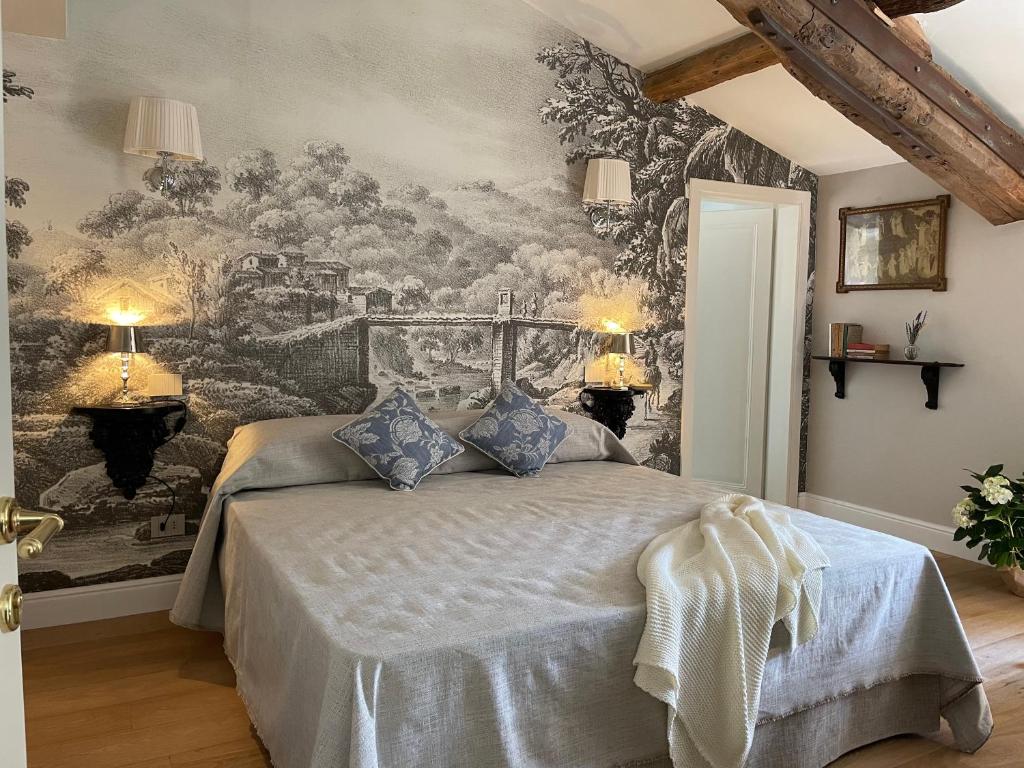a bedroom with a bed with a painting on the wall at Burlamacchi Villas in Bagni di Lucca