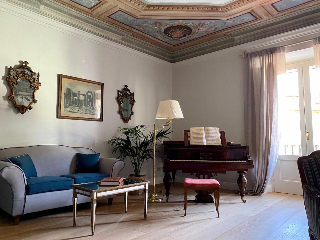 a living room with a couch and a piano at Burlamacchi Villas in Bagni di Lucca
