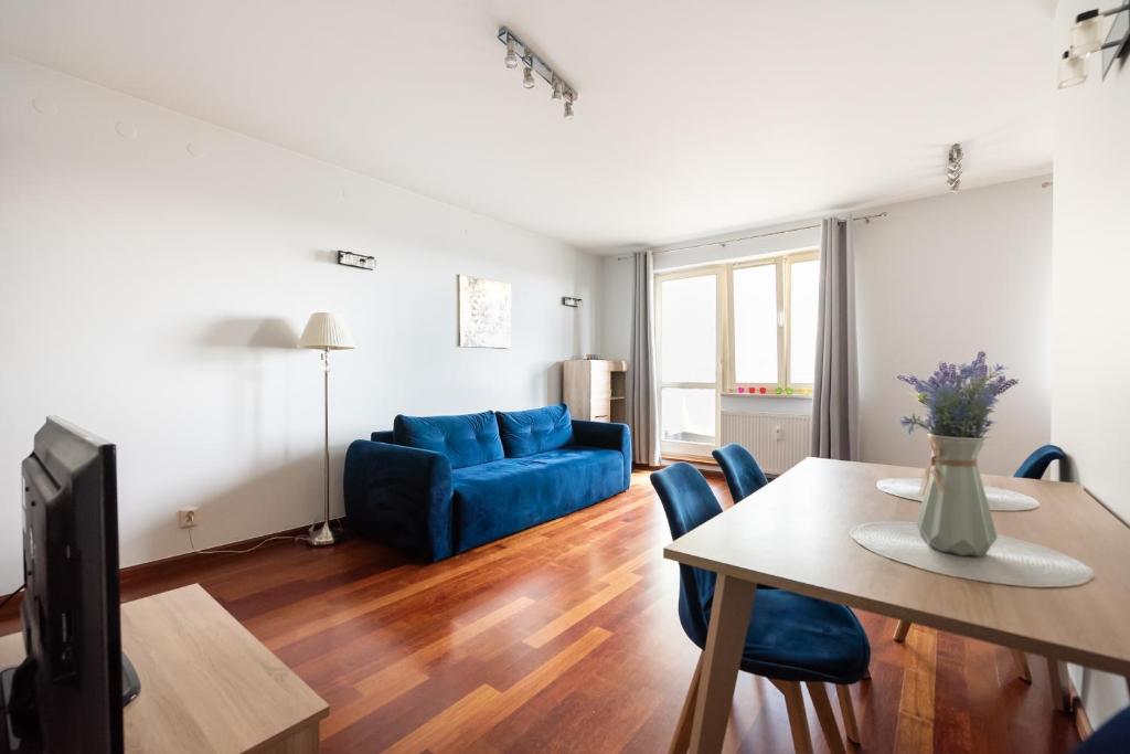 a living room with a blue couch and a table at Mokotów Open Business Apartment in Warsaw