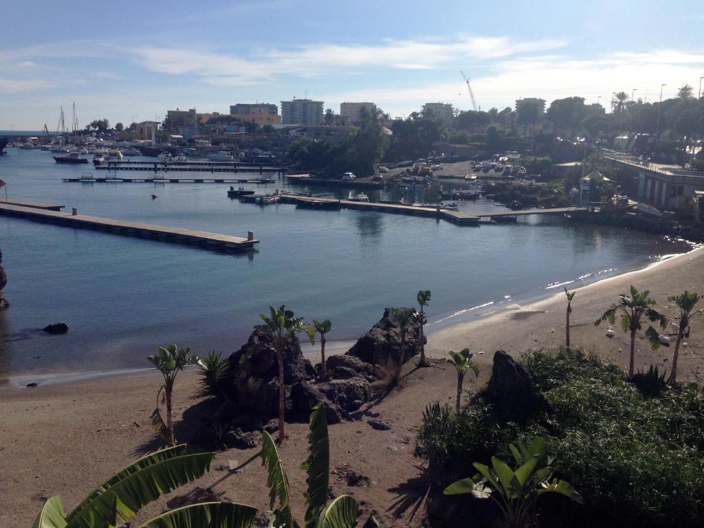 a view of a river with a beach and a pier at Baia Di Ognina in Catania