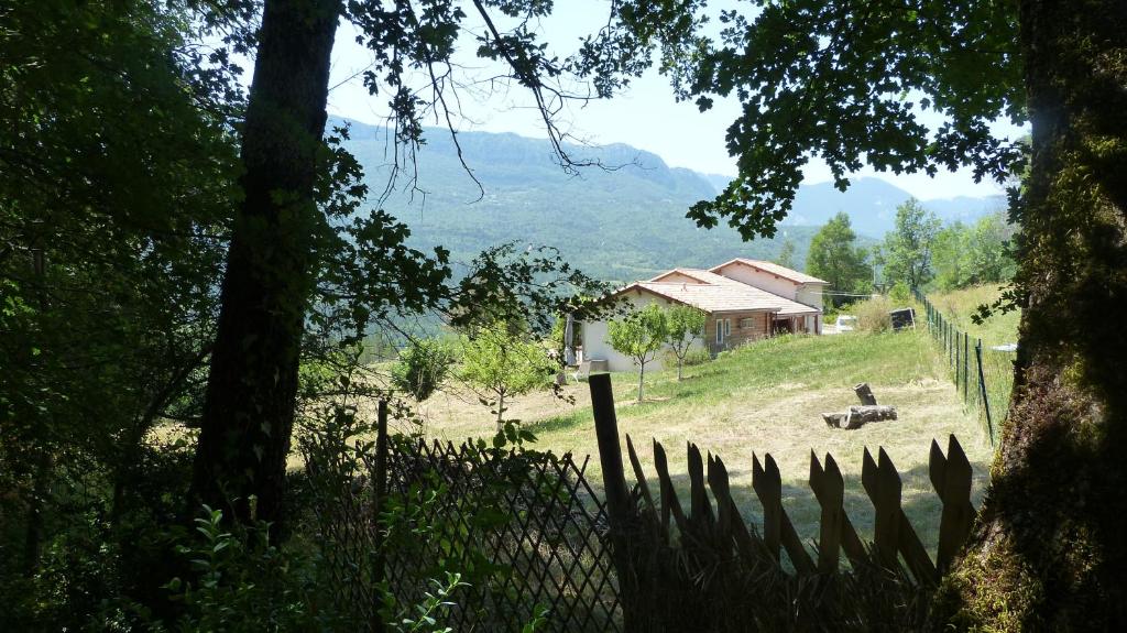 a farm with a fence and a cow in a field at La Prairie in Noyers-sur-Jabron