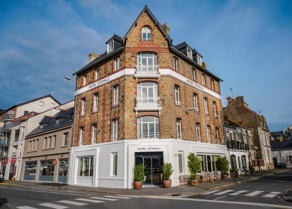 a large brick building on a city street at Otonali Hôtel by Breizh Café in Saint Malo