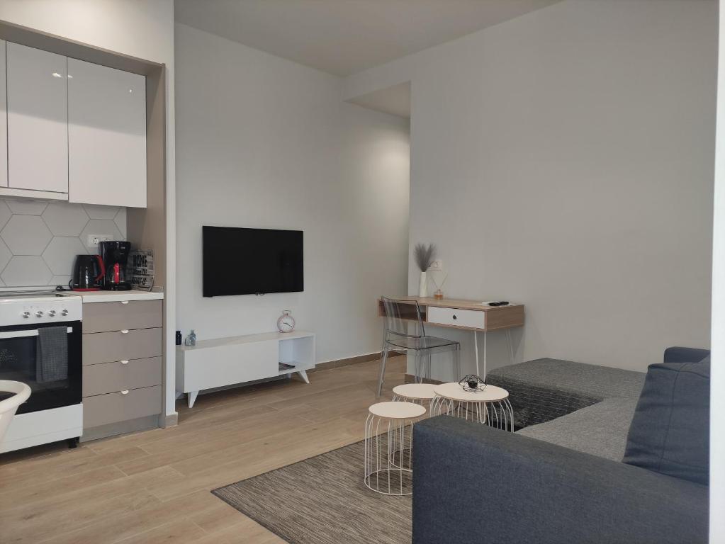 a white living room with a couch and a kitchen at Partcon Apartment B in Neoi Epivates