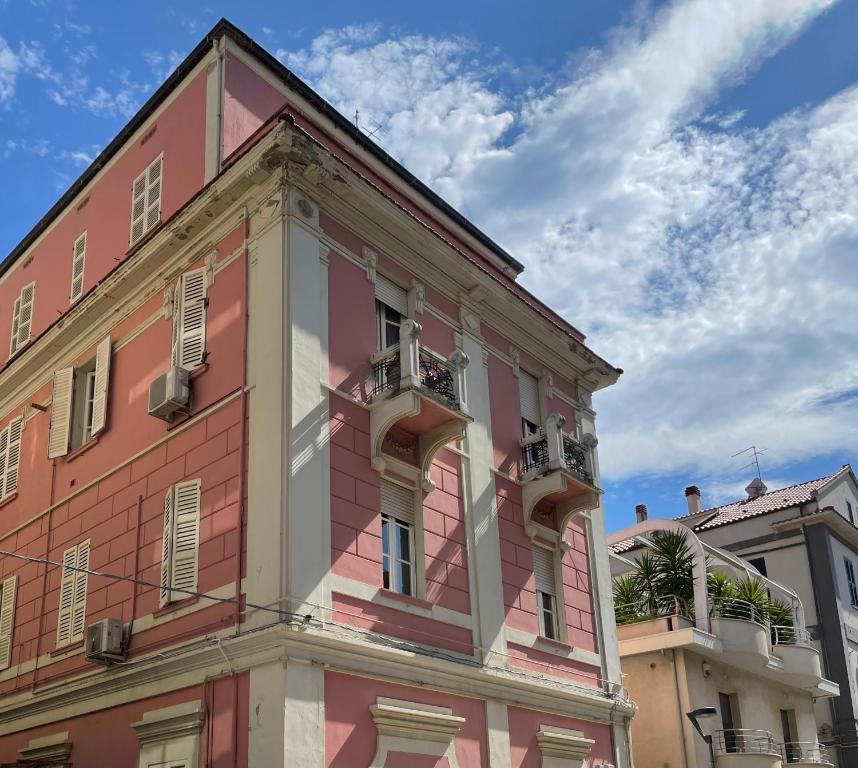 ペスカーラにあるDa Zio Giovanniのピンクの建物で、バルコニーが2つあります。