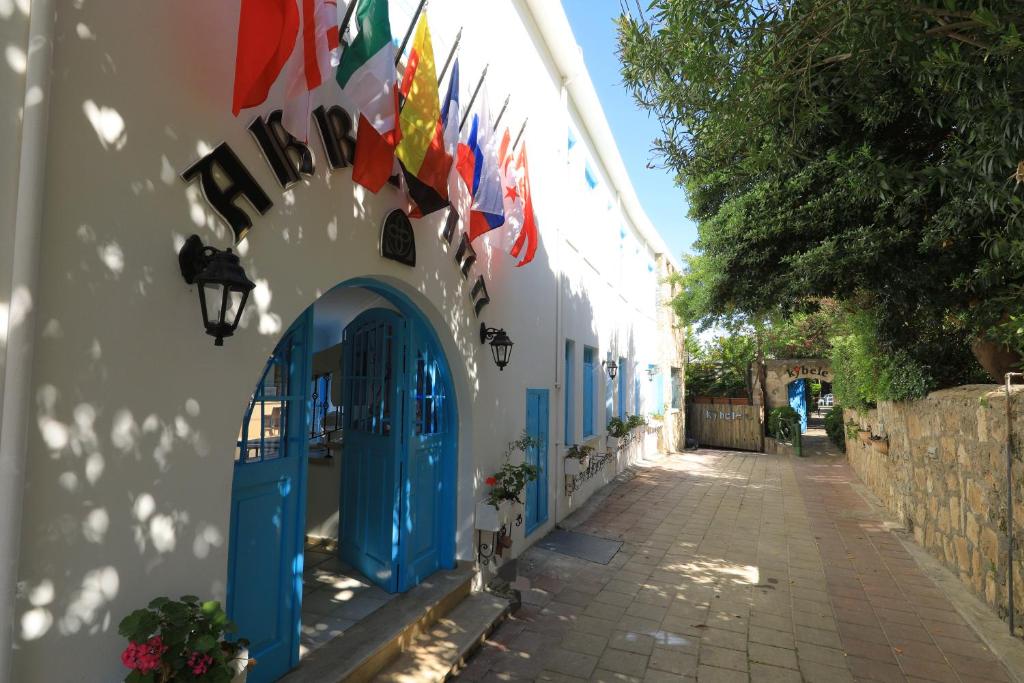 ein Gebäude mit blauen Türen und Flaggen auf einer Straße in der Unterkunft Bellapais Abbey Boutique Hotel in Kyrenia