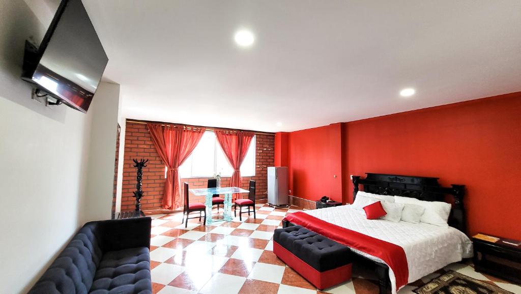 a bedroom with red walls and a bed and a couch at Hotel Beijing Caucasia in Caucasia
