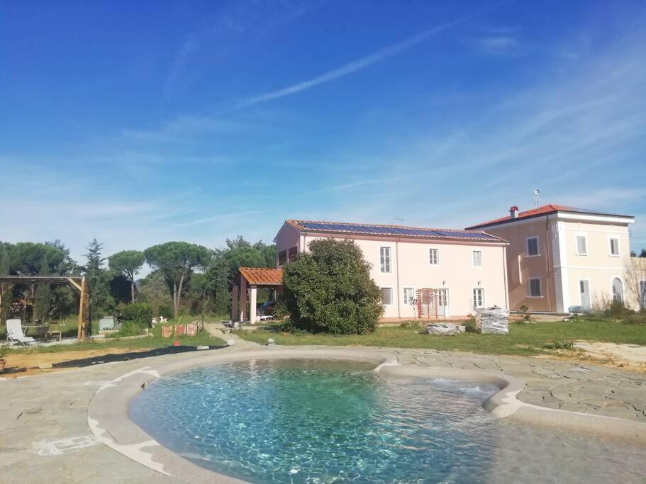 a large pool of water in front of a house at Villa Donnola: casa Rosmarino in Fucecchio