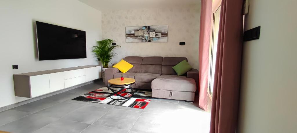 a living room with a couch and a tv at Apartment Denis in Krk