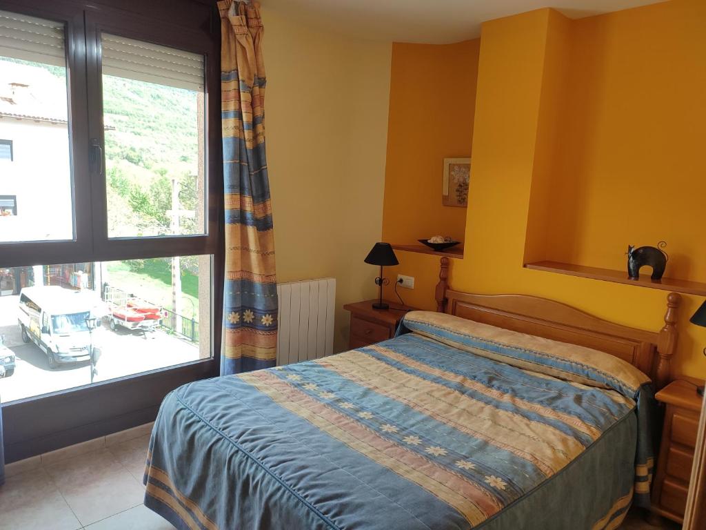 Un dormitorio con una cama y una ventana grande. en Apartamentos Casa Modesto, en Escalona