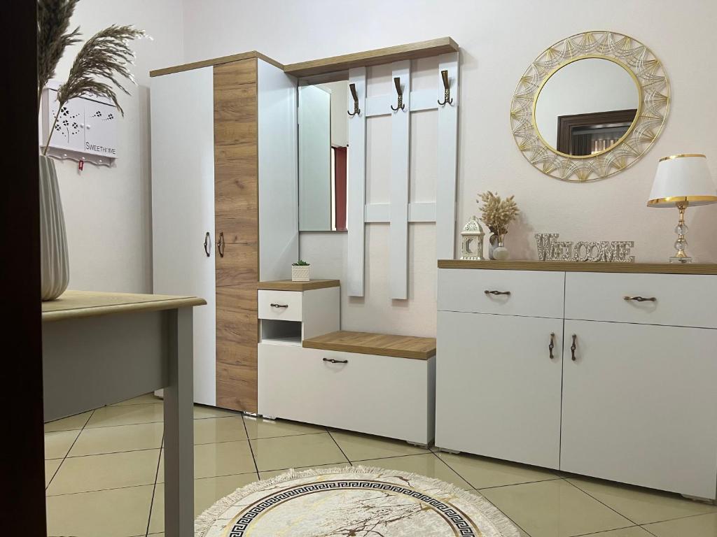 a kitchen with white cabinets and a mirror at SaEl Apartments in Shkodër