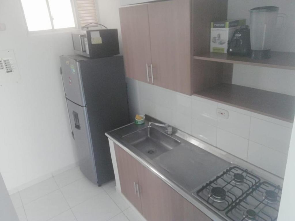 a kitchen with a sink and a refrigerator at XXXXXX Apartamento amoblado #FESTIVALVALLENATO, MInimo 4 noches in Valledupar