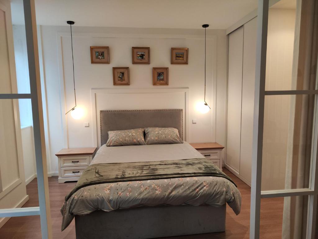um quarto com uma cama com duas mesas e dois candeeiros em Casa Moliceiro Verde em Aveiro