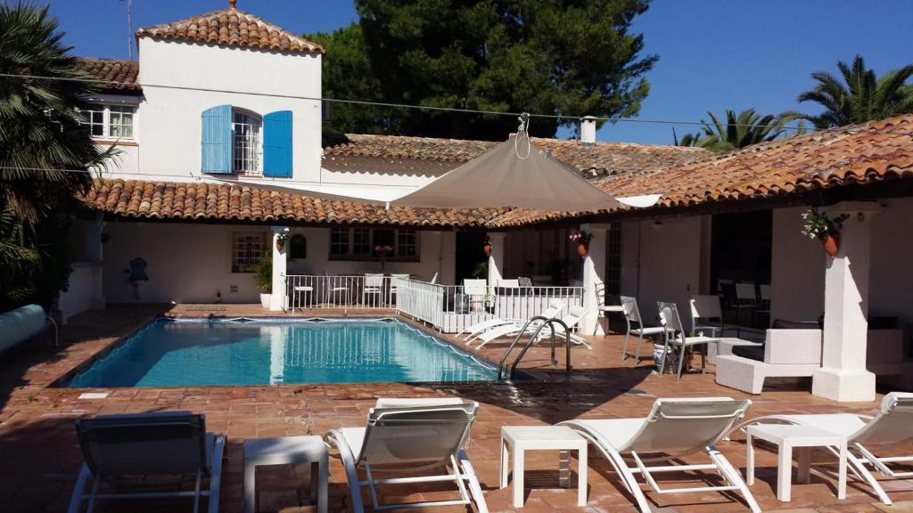 basen z krzesłami i dom w obiekcie Le Grau d'Agde: A vivre en famille et entre amis w mieście Le Grau-dʼAgde