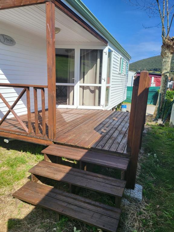 a wooden deck on the side of a house at camping Pradon in Arnuero