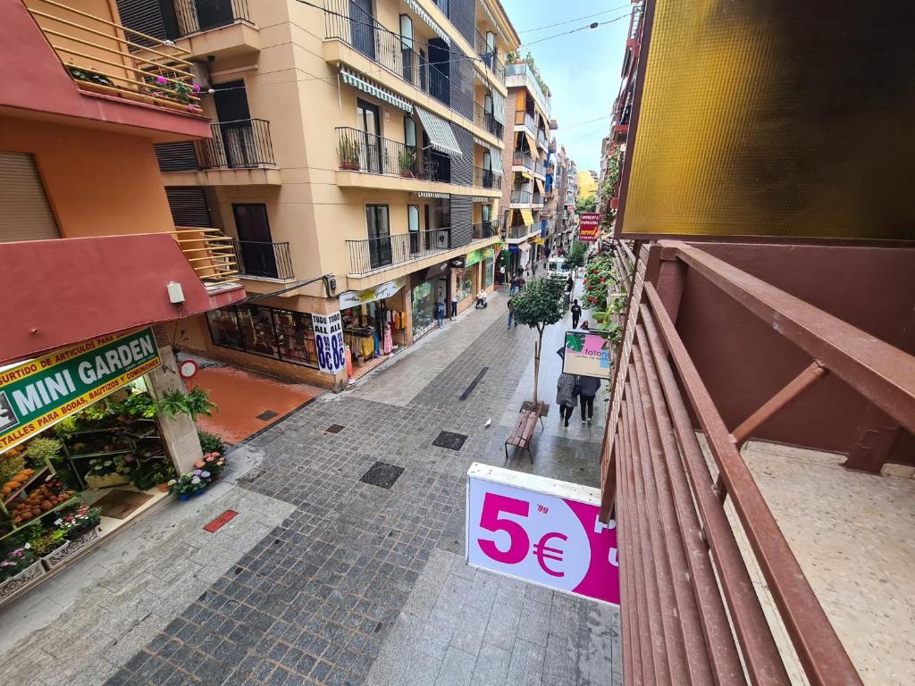 una strada vuota con un cartello di vendita sul balcone di Apartamento Edificio El Cid a Benidorm