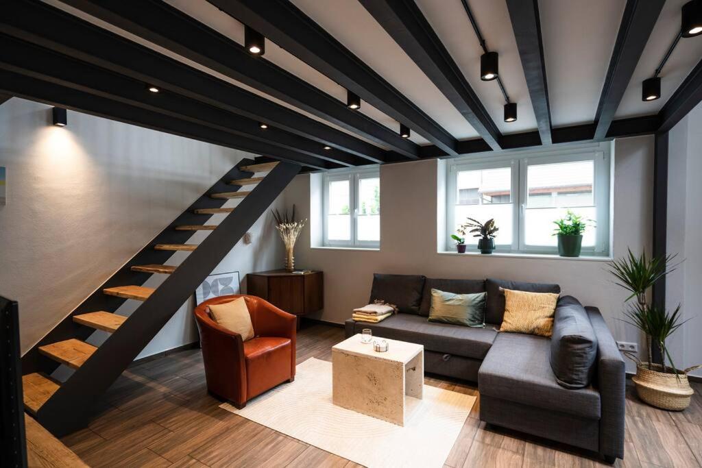 un soggiorno con divano e una scala di Apartment in Weinstadt-Schnait a Weinstadt