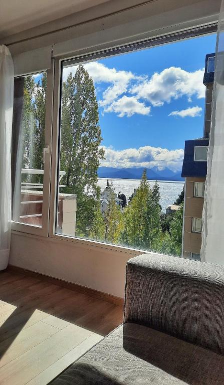 Zimmer mit einem großen Fenster mit Blick auf das Wasser in der Unterkunft Modern apartment with view in San Carlos de Bariloche