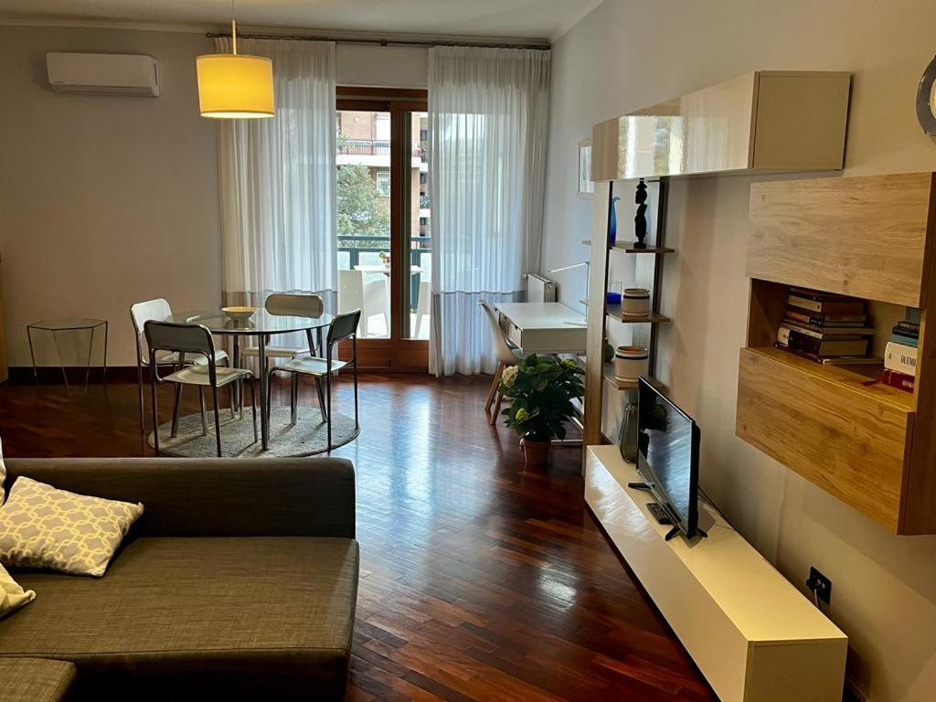 uma sala de estar com um sofá e uma sala de jantar em INTERO APPARTAMENTO EUR Torrino NUOVO LiFeHome em Roma