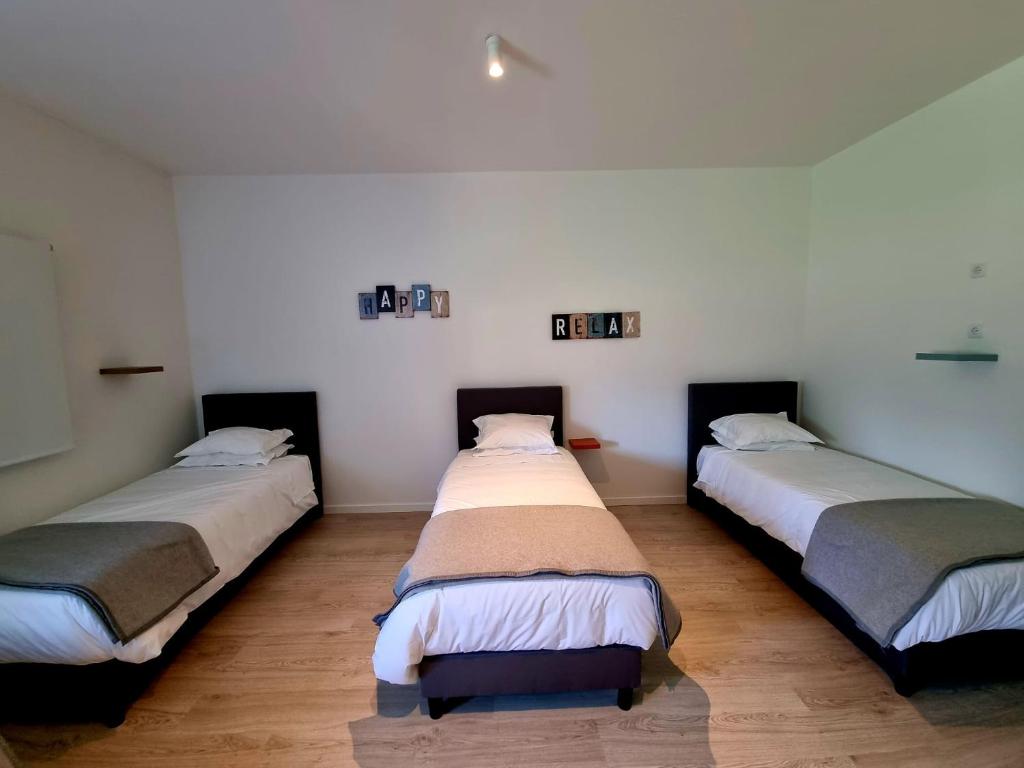 a room with three beds in a room at Azulrelax Hostel in Pinhal Novo
