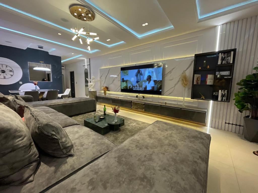 sala de estar con sofá y TV de pantalla plana en Magnificent 3-Bedroom in VI en Lagos