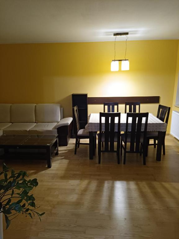 a dining room with a table and chairs and a couch at Apartament do wynajęcia in Olecko