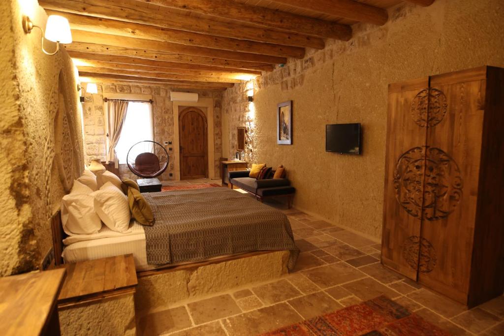 a bedroom with a bed and a tv in a room at Vita Cave Suites in Urgup